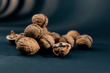 Koyu mavi bir arka planda yan ışıklandırmayla yakın plan yan yatar ve sonbahar meyveleri kırılır.