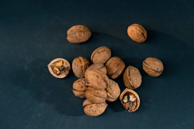 Üst çekim koyu mavi bir arka planda yan ışıklandırmayla bir bütün olarak yatar ve sonbahar meyveleri kırılır.