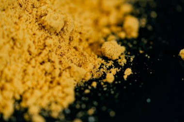 Koyu mavi arka planda, yan ışıklandırması Hint baharatlarının sarı zerdeçal doğu mutfağında yatar.