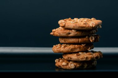 Siyah ve mavi arka planda düz siyah bir tabağa yakın. Piramit şeklinde kurabiyeler, tatlı bir mutfak, temiz bir alan.