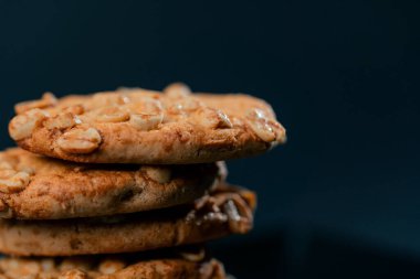 Siyah ve mavi arka planda düz siyah bir tabağa yakın. Piramit şeklinde kurabiyeler, tatlı bir mutfak, temiz bir alan.