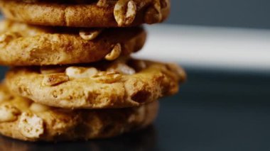 Siyah ve mavi arka plan düz bir tabağa yakın. Piramidin içine yerleştirilmiş kurabiye kurabiyeleri ve dağınık mutfak fıstıkları.