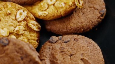 Masanın üzerinde kaotik bir şekilde duran kurabiyelerle siyah ve mavi arka plan düz tabağa yaklaş tatlı mutfak tatlı kahvaltısı