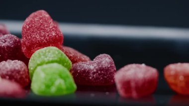 Siyah, uzun bir tabakta çok renkli tatlı bir jöle serpiştirilmiş şeker çeşitli meyveler çocuklar için lezzetlidir.