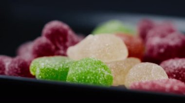 Siyah, uzun bir tabakta çok renkli tatlı bir jöle serpiştirilmiş şeker çeşitli meyveler çocuklar için lezzetlidir.