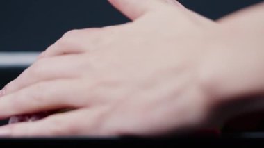 Siyah, uzun bir tabakta çok renkli tatlı bir jöle serpiştirilmiş, çeşitli meyveler serpiştirilmiş. Kadın eli her şeyi alır ve atar.