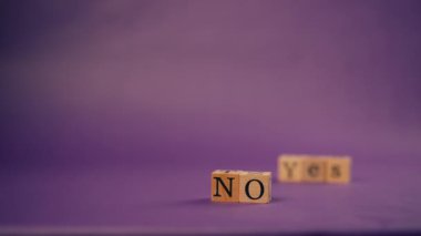 Siyah harflerle yazılan siyah tahta küplerle mor, sıcak bir arka plan.