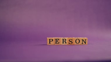 Siyah harflerle yazılan siyah tahta küplerle mor, ılık bir arka plan ve Vip persona harfleri.