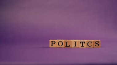 Mor, sıcak bir zemin, gölgeli tahta küplerle siyah harflerle ve politikadan harfler serpiştirilmiş.