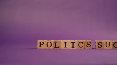 Mor, sıcak bir arka plan, gölgeli ahşap küplerle siyah harflerle ve siyasetin berbat olduğu harflerle yazılmış kelimeler.