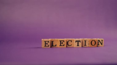 Siyah harfli, gölgeli tahta küplerle mor, ılık bir arka plan ve seçim mektuplarından alıntılar.