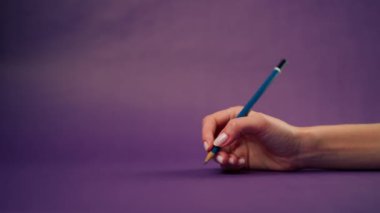 Güzel bir kadın eli, mor bir arka planda izole edilmiş çıplak bir el ve mavi kalem kalibreli kaligrafi.