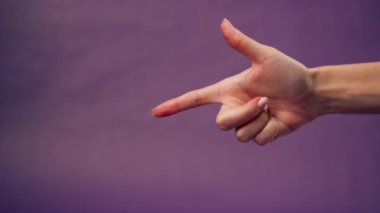 Güzel bir kadın eli mor arka planda izole edilmiş çıplak manikür elinde çatışma işaret parmağında tatminsizlik var.