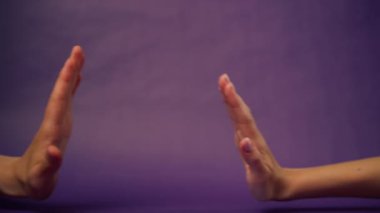 Güzel bir kadın eli mor arka planda izole edilmiş iki avuç içi açık işaret dili çak bir beşlik.