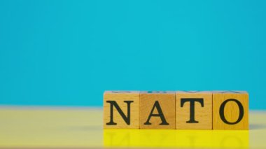 Ukrayna bayrağı mavi ve sarı sıcacık arkaplan ve gölgeli kadın eli siyah harfli tahta küpler koydu NATO 'ya