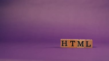 Siyah harfli ve gölgeli tahta küplerle mor, ılık bir arkaplan ve HTML harflerinden kelimeler serpiştirilmiş.