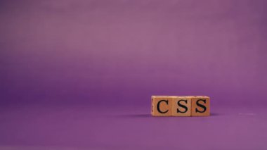 Siyah harfli, gölgeli tahta küplerle mor, ılık bir arka plan ve CSS harflerinden sözcükler.
