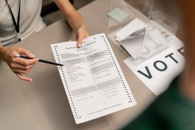Seçim şirketinin seçim komitesinde oy vermek için başvuran bir erkek, genç bir kızın toplumun haklarını nasıl kullanacağını söyler.
