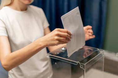 Başkanlık seçimleri için oy kullanma bölgesinde beyaz elbiseli genç kız sandık başına gençlik seçimleri için oy kullanıyor.