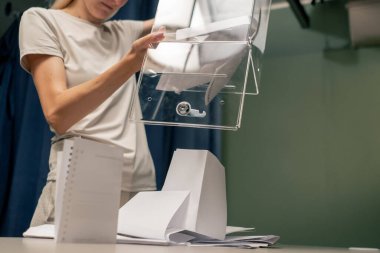 Başkanlık seçimleri sırasında oy sandığı komisyonu çalışanı adil seçimleri ihlal etmemek için oy pusulalarını masaya döker.