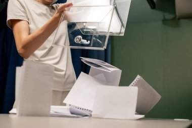 Başkanlık seçimleri sırasında oy sandığı komisyonu çalışanı adil seçimleri ihlal etmemek için oy pusulalarını masaya döker.