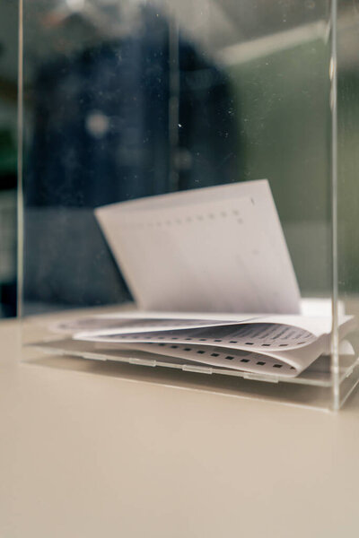 во время президентских выборов за столиком для голосования стоит маленькая урна с бюллетенями для голосования