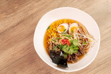 Bir restoranda, açık bir masada, Japon udon çorbası, yumurta ve erişte karışımı Japon hafif çorbası ile yakın çekim.