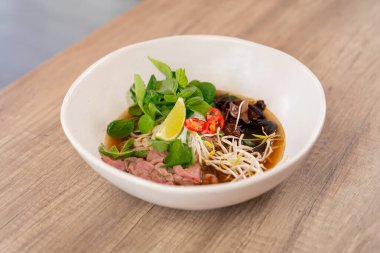 Lokantada, açık bir masada, Japon udon çorbası, et, mantar ve erişte karışımı Japon hafif çorbası.