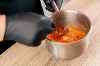 Fast food işletmelerinde yakın plan: Ahşap bir masanın üzerinde siyah üniformalı büyük bir aşçı tencereden karides alır.