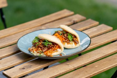 Caddedeki bir restorana yakın, tahta bir masanın üzerinde, güneşte iki kişilik Meksika pidesi olan mavi bir tabak, hafif diyet yiyecekler.