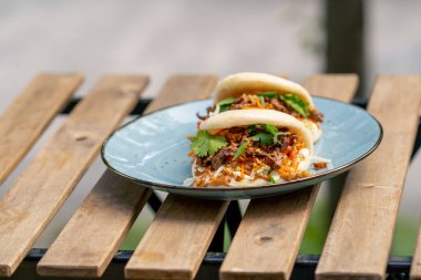 Caddedeki bir restorana yakın, tahta bir masanın üzerinde, güneşte iki kişilik Meksika pidesi olan mavi bir tabak, hafif diyet yiyecekler.