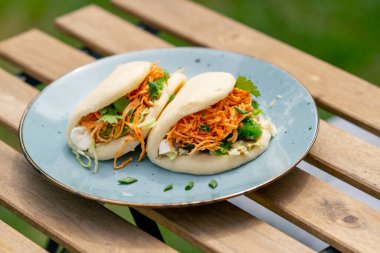 Caddedeki bir restorana yakın, tahta bir masanın üzerinde, güneşte iki kişilik Meksika pidesi olan mavi bir tabak, hafif diyet yiyecekler.