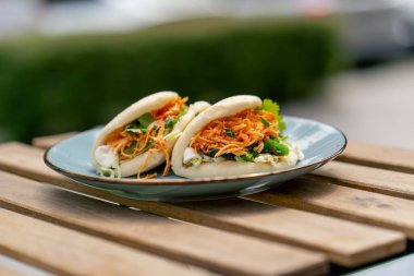 Caddedeki bir restorana yakın, tahta bir masanın üzerinde, güneşte iki kişilik Meksika pidesi olan mavi bir tabak, hafif diyet yiyecekler.