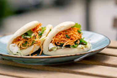 Caddedeki bir restorana yakın, tahta bir masanın üzerinde, güneşte iki kişilik Meksika pidesi olan mavi bir tabak, hafif diyet yiyecekler.