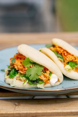 Caddedeki bir restorana yakın, tahta bir masanın üzerinde, güneşte iki kişilik Meksika pidesi olan mavi bir tabak, hafif diyet yiyecekler.