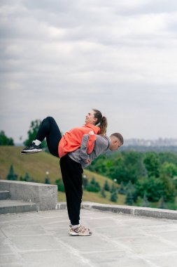 Parkta birbirine aşık genç bir çift spor yapıyor. Sağlıklı yaşam tarzı senkronize hareketleri ısıtıyor.