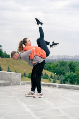 Parkta birbirine aşık genç bir çift spor yapıyor. Sağlıklı yaşam tarzı senkronize hareketleri ısıtıyor.