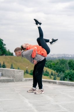 Parkta birbirine aşık genç bir çift spor yapıyor. Sağlıklı yaşam tarzı senkronize hareketleri ısıtıyor.