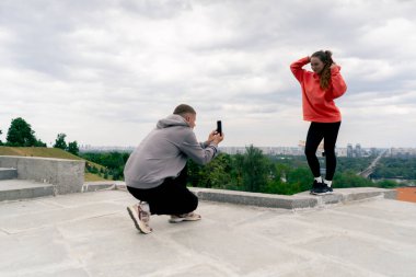 Parkta genç bir çift spor sonrası fotoğraf çekiminden sonra fotoğraf çekiyor.