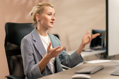 Aydınlık bir ofiste sarışın genç bir çalışan beyaz bir ekranda çalışıyor modern ofis ışınları bir projede çalışıyor zoom üzerinde