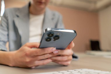 Kadın genç ellerin telefon bürosuna profesyonel klavyeye mesaj yazarken yakın plan çekimleri.