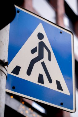 Yayalar ve yayalar arasındaki mavi-beyaz yol iletişiminin sokak tabelasını kapatın.