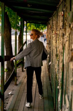 Şehirde, açık renk ceketli bir kız, reklamlarla kaplı inşaat kaplı bir yayanın içinden geçiyor. Sağlıklı bir yaşam tarzı