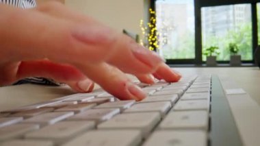 Beyaz ofis aletinin klavyesinde yazı yazan ve basan genç kadınların yakın plan fotoğrafları, çıplak manikür, profesyonel klavye