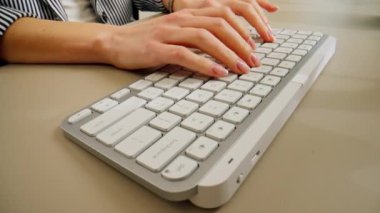 Beyaz ofis aletinin klavyesinde yazı yazan ve basan genç kadınların yakın plan fotoğrafları, çıplak manikür, profesyonel klavye