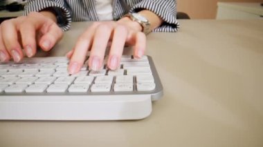 Beyaz ofis aletinin klavyesinde düğmeye basan genç kadınların yakın çekimi, çıplak manikür, profesyonel klavye