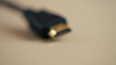 Açık bej bir masanın üzerinde monitör güç kaynağı kablolarını bağlamak için bir HDMI kablosu var.