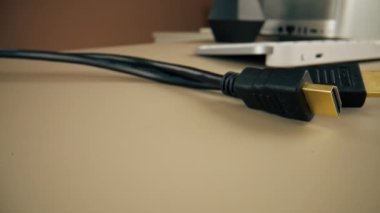Açık bej bir masanın üzerinde monitör güç kaynağı kablolarını bağlamak için bir HDMI kablosu var.