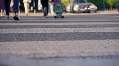 Şehir otoyolunun merkez kısmında farklı yabancı arabalarla insanların yoldan geçerken asfalt hareketine odaklanıyoruz.