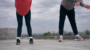 Parkta birbirine aşık genç bir çift spor yapıyor. Sağlıklı yaşam tarzı senkronize hareketleri ısıtıyor.